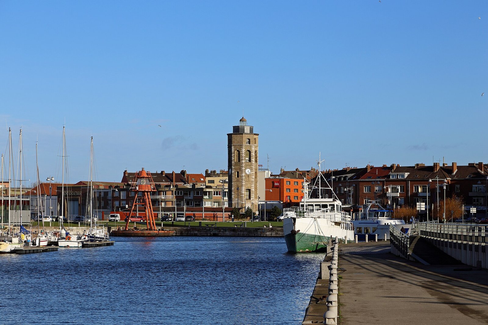 La tour du Leughenaer domine les toits de brique et les mâts du port de plaisance.
